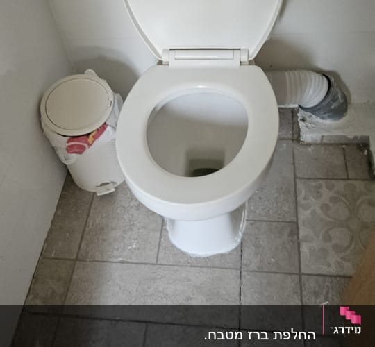 אסלה לבנה עם צינור חיבור לקיר